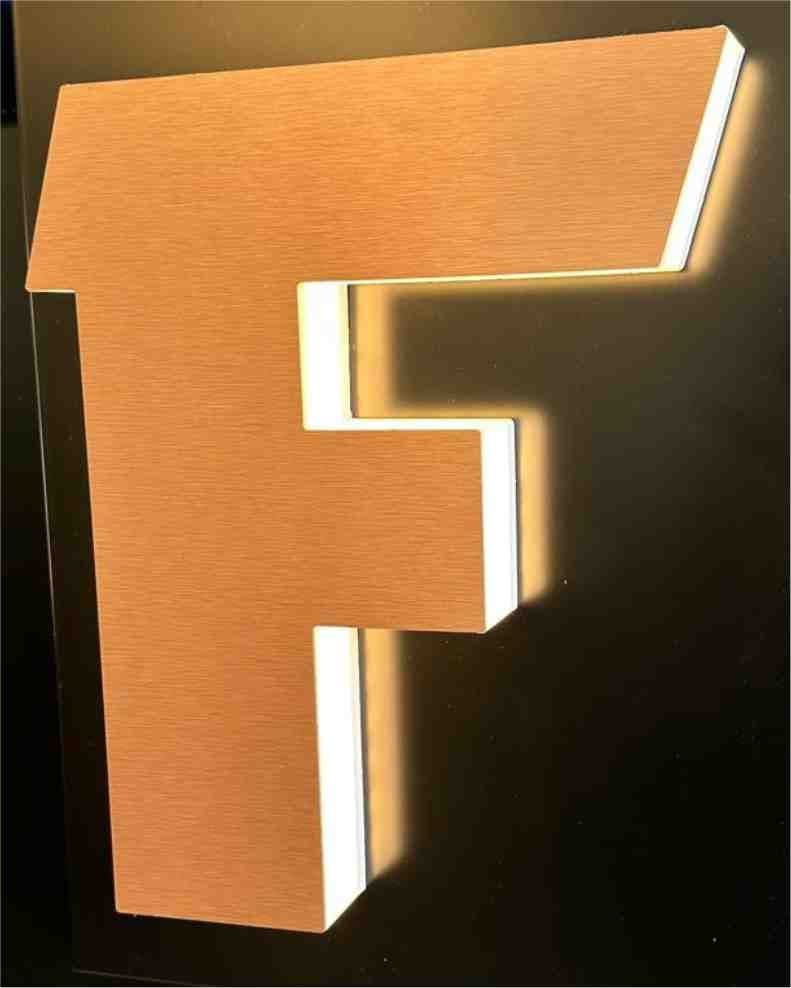 A letter F with a brushed face and light glowing through its translucent returns