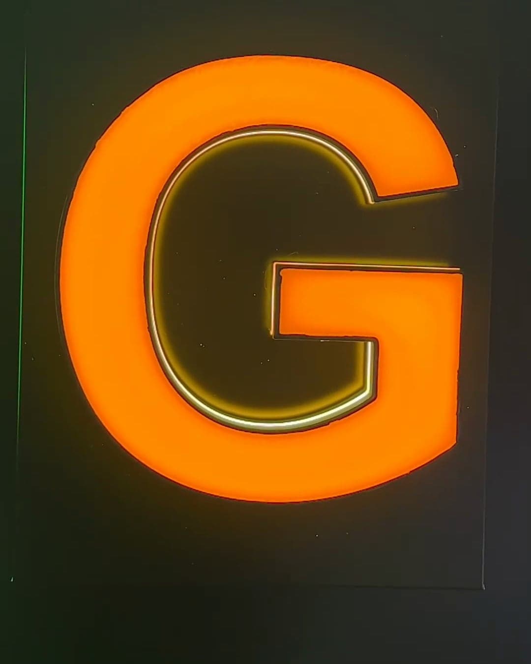 The same letter G lit, its face glowing orange