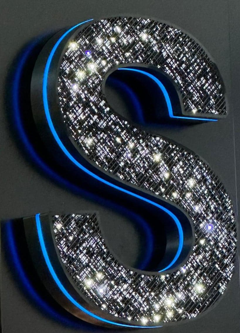 A letter S with a starry face and a blue lit edge along its returns