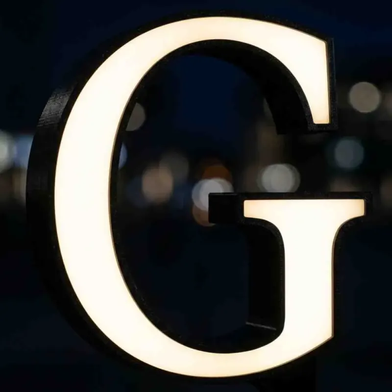Close-up of an evenly illuminated 3D-printed letter face, showing smooth light diffusion